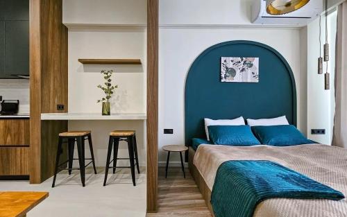 a bedroom with a bed with a blue headboard at MaRKoS Sea View Apartment Bamboo Beach in Ts'ikhisdziri