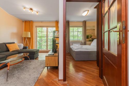 a living room with a couch and a bed at Grand Apartments - Patio Mare Apartments in Sopot