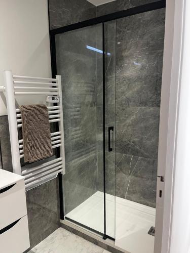 une douche avec une porte vitrée dans une salle de bain dans l'établissement Villa Lavande, à Sainte-Maxime