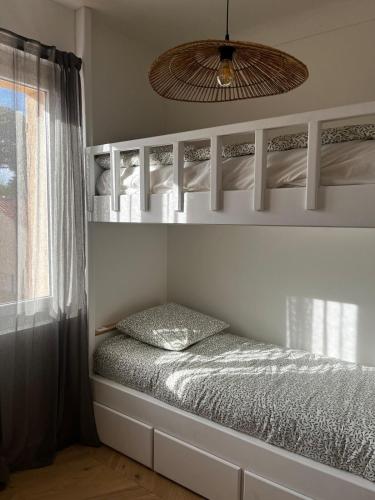 une chambre avec deux lits superposés et une fenêtre dans l'établissement Villa Lavande, à Sainte-Maxime