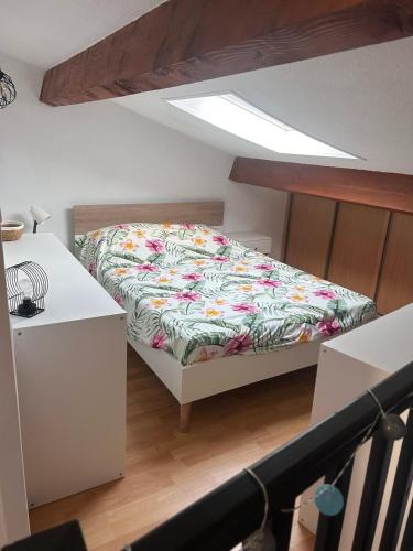 une chambre avec un lit avec un couvre-lit fleuri dans l'établissement Maisonnette Mail Rochelongue location samedi au samedi, au Cap d'Agde