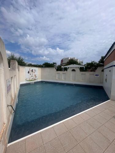 une piscine sur le côté d'un immeuble dans l'établissement Maisonnette Mail Rochelongue location samedi au samedi, au Cap d'Agde