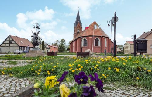 a field of flowers in front of a church at 4 Bedroom Amazing Home In Nowe Warpno in Nowe Warpno