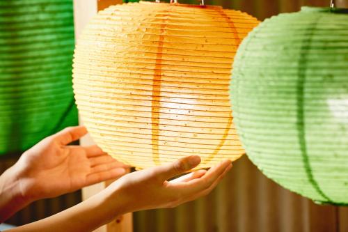 a person holding a paper lantern with their hands at BEB5 Tsuchiura by Hoshino Resorts in Tsuchiura