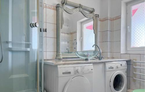 a bathroom with a washing machine and a mirror at 4 Bedroom Amazing Home In Nowe Warpno in Nowe Warpno