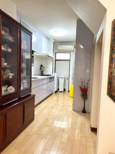 a kitchen with white cabinets and a wooden floor at 日式庭院豪宅 in Kita-tsunashimachō