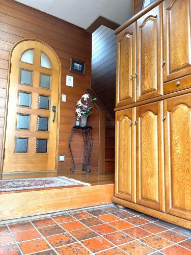 a kitchen with wooden cabinets and a door at 日式庭院豪宅 in Kita-tsunashimachō