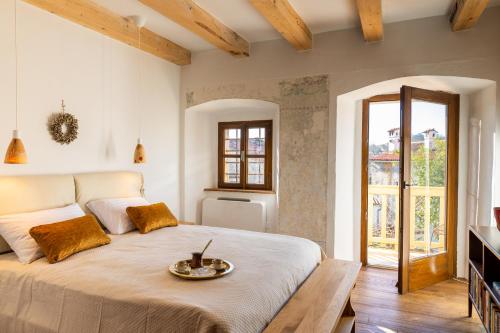a bedroom with a large bed with a tray on it at Vila Kobdilj 1835 - Unique Stay in Karst Stone Villa in Štanjel
