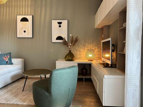 un salon avec un canapé et une chaise dans l'établissement 660-Apprt T2 à 250m de la plage du centre d'Erquy, à Erquy