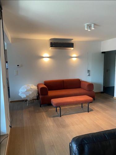 a living room with a brown couch and a table at Business Accommodation Luxury XL Geel in Geel