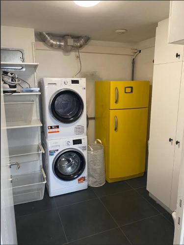 a kitchen with a washing machine and a yellow refrigerator at Business Accommodation Luxury XL Geel in Geel