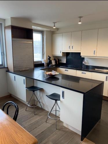 a kitchen with a black counter and stools at Business Accommodation Luxury XL Geel in Geel