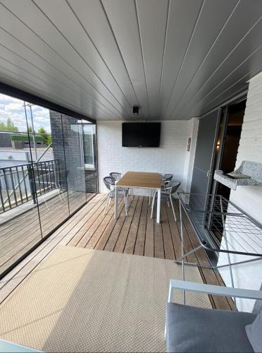 a room with a table and a television on a balcony at Business Accommodation Luxury XL Geel in Geel