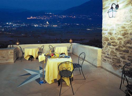 einen Tisch und Stühle auf einer Terrasse in der Nacht in der Unterkunft Relais La Corte di Bettona in Bettona