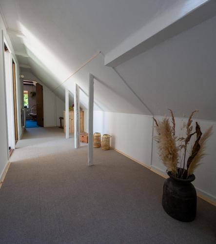 a hallway with a vase with a plant in it at Holmely Bed & Breakfast in Brædstrup