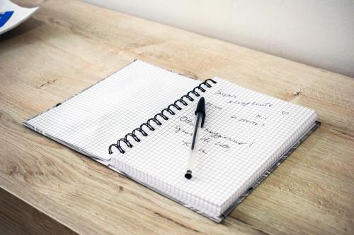 an open notebook with a pen on a table at Domus Vacanze 2 in Altamura