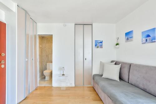 un salon avec un canapé et une salle de bains. dans l'établissement Superbe studio à proximité de la Tour Eiffel, à Paris