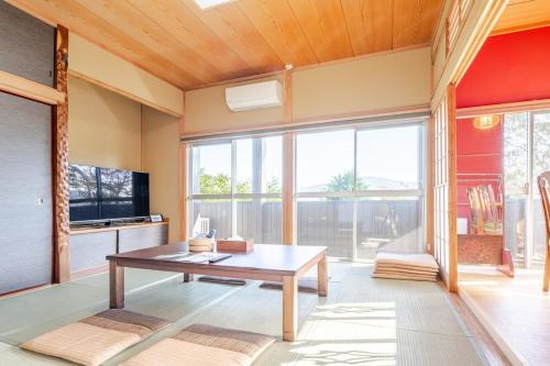 a living room with a table and a large window at 箱根御泊処-縁- 044h in Hakone