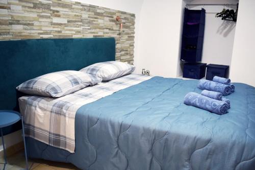 a blue bed with pillows on top of it at Domus Vacanze 2 in Altamura