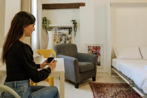 a woman sitting in a room holding a remote control at Yourbanflat Art Loft in Padova