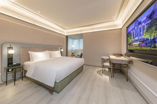 a hotel room with a bed and a tv at Mercure Fuzhou Downtown in Fuzhou
