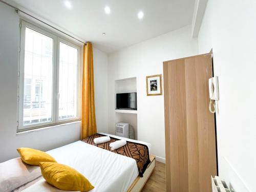 une petite chambre avec un lit et une fenêtre dans l'établissement 32 Atelier Paris Fashion, à Paris