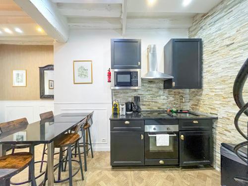 une cuisine avec une cuisinière et une table avec des chaises dans l'établissement 32 Atelier Paris Fashion, à Paris