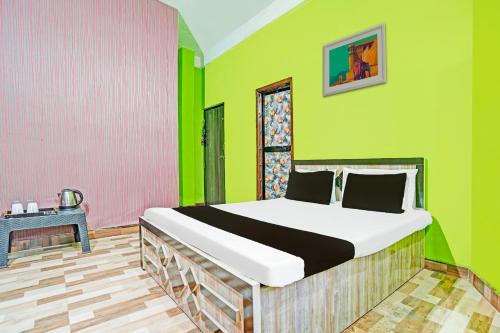 a bedroom with a bed with green and pink walls at Hotel O New Shan-e-Punjab Veer Restaurant and lodging in Kāmthi