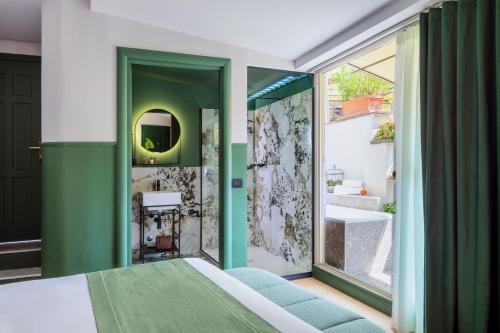 una camera da letto con una parete verde e un bagno con lavandino di Hotel Concordia a Roma