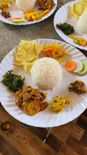 three plates of food on a table with rice and vegetables at Mundum Farm Stay in Dhulikhel