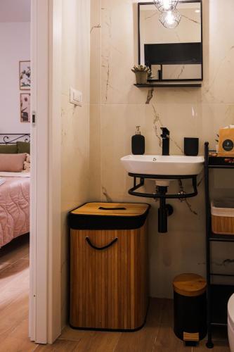 a bathroom with a sink and a wooden stool at Il Giardino di Sole in Bari