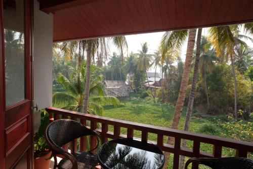 a balcony with a view of the palm trees at Asoca Hotel Luang Prabang in Luang Prabang