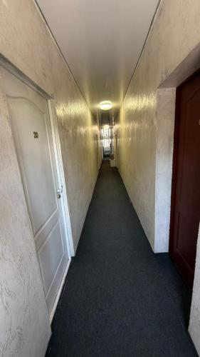 a hallway with a long corridor with a door and a room at Пана in Almaty