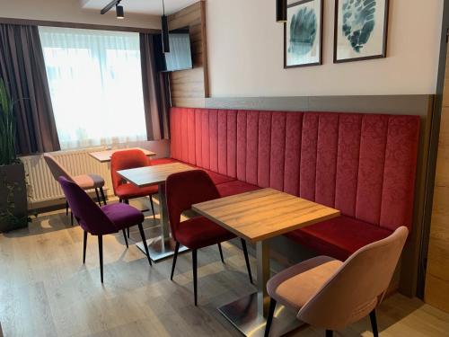 a restaurant with red booths and wooden tables and chairs at wild & bolz eMotel in Trieben