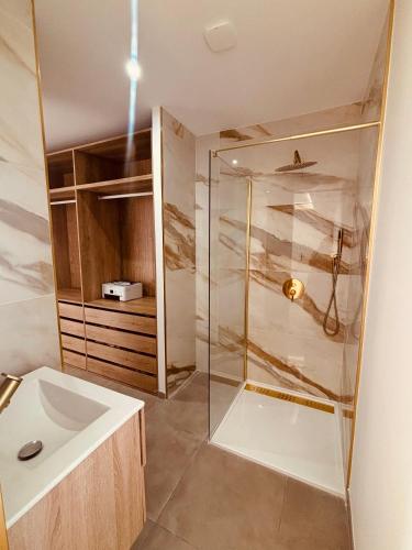 une salle de bain avec une douche en verre et un lavabo dans l'établissement Villa moderne privée avec piscine, vue montagne 3 chambres, à Pennautier