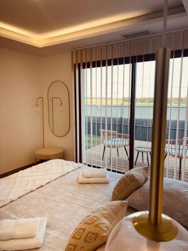 une chambre avec un grand lit et un balcon dans l'établissement Villa moderne privée avec piscine, vue montagne 3 chambres, à Pennautier