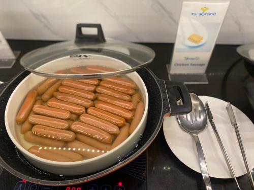 a pan full of hot dogs in a sauce at Ingnaam Hotel in Ban Talat Rangsit