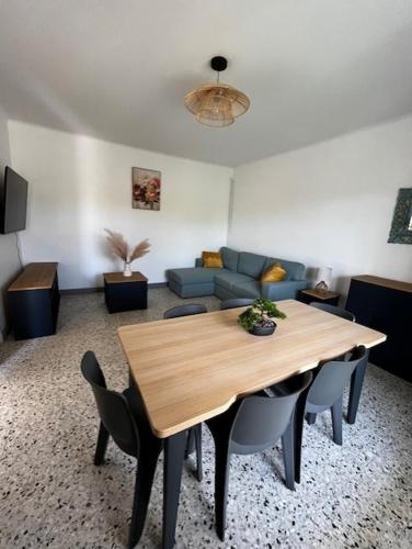 un salon avec une table en bois et un canapé dans l'établissement Charmant appartement rénové, à 15 mn d'Avignon et de son festival, à Entraigues-sur-la-Sorgue