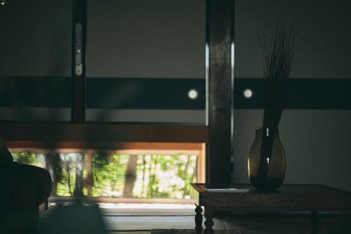 a vase sitting on a table next to a window at MUJI BASE kamogawa in Kamogawa