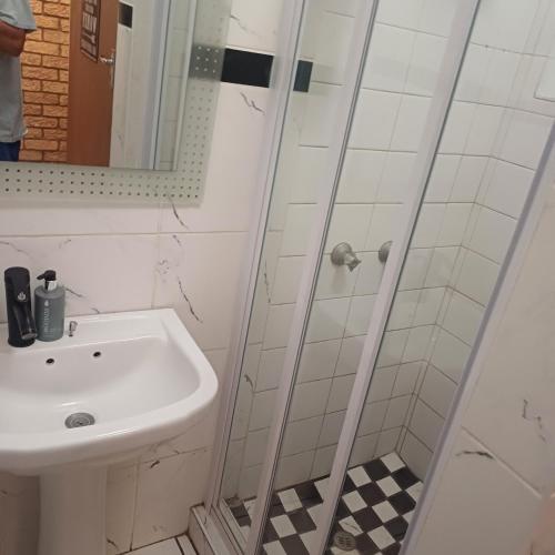 un baño con lavabo y ducha en Linga Longa, en Beaufort West