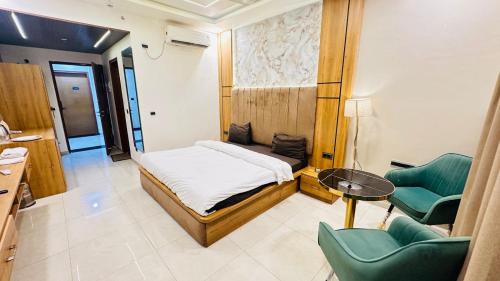 a bedroom with a bed and a table and chairs at Snooze and Stay Omaxe Hazratganj in Lucknow