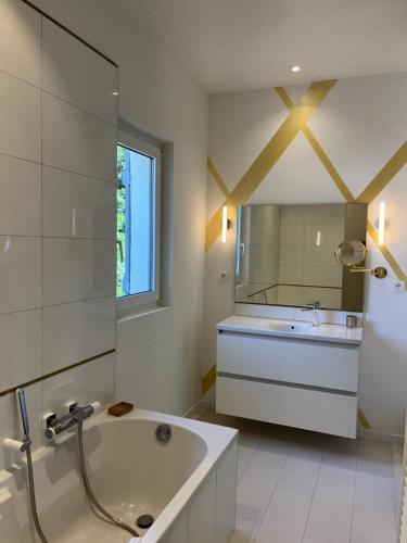 une salle de bain avec une baignoire, un lavabo et un miroir dans l'établissement Villa avec piscine et salle de sport, à Castries