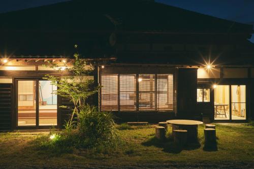 a house with a table in front of it at night at MUJI BASE kamogawa in Kamogawa