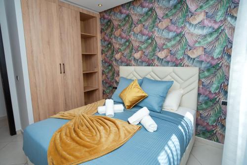 a bedroom with a blue bed with a colorful wallpaper at Blue Palm Pool, quiet and comfort in Tangier in Tangier