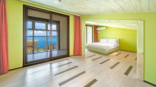 a bedroom with a bed and a view of the ocean at Geojedo Pilos Ocean View Pension in Geoje 