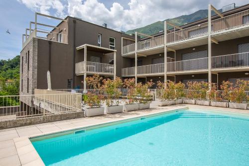 ムッソにあるLarius Apartment-Residence with Pool on Lake Comoの建物の前にプールがある建物