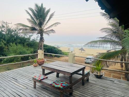 a wooden deck with a picnic table and a view of the beach at The View - Xai Xai Mozambique Xai Xai Beach Front 180 Degree Sea Views in Xai-Xai
