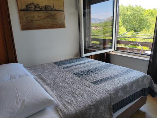 una camera da letto con un letto e una grande finestra di Rajski vrt a Crikvenica