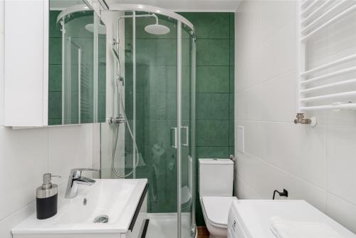 a bathroom with a shower and a sink and a toilet at Piotrkowska Sunset Apartment in Łódź