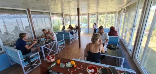 a group of people sitting at tables in a restaurant at Mundum Farm Stay in Dhulikhel